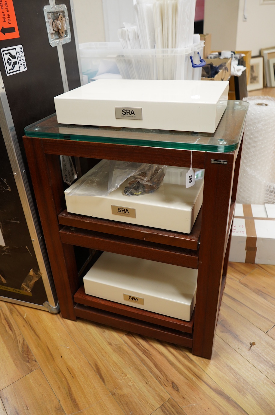 A three section Soundbox HiFi stereo stand in teak, 83cm high, 66cm wide, 46.5cm deep, together with three Silent Running Audio (SRA) Ohio Class high end audio base units in cream cases (designed to reduce vibration) - o